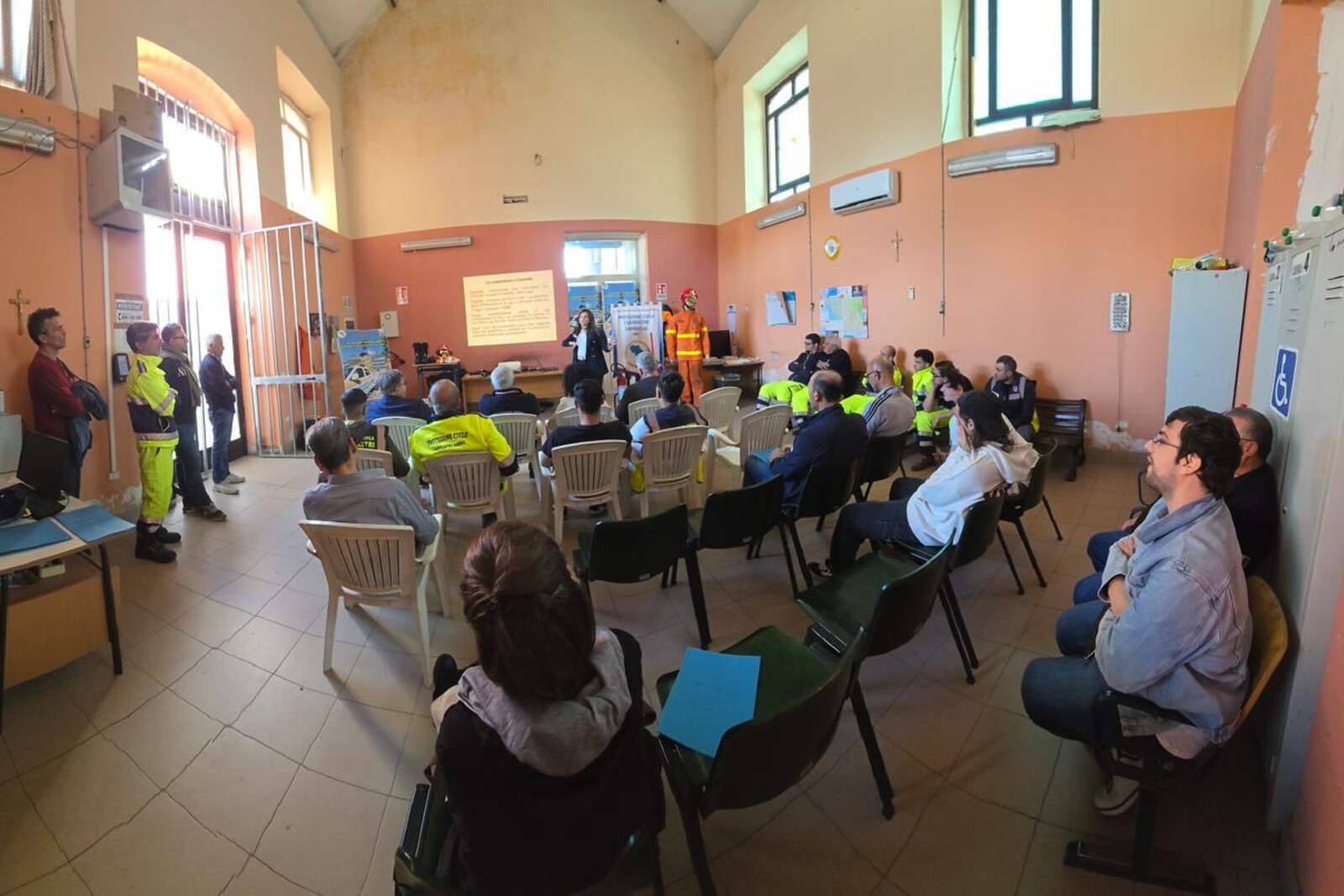 Aula di un corso di formazione FP: i partecipanti seguono la lezione, il docente presenta davanti allo schermo